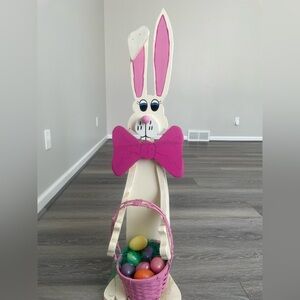 Wooden porch greeter bunny with basket full of eggs for easter.